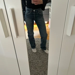 Raka widwaist jeans  - Snygga blå jeansbyxor med klassisk design. De har en rak passform och är perfekta för en avslappnad stil. Byxorna har en knappgylf och fem fickor, vilket ger en tidlös look.
