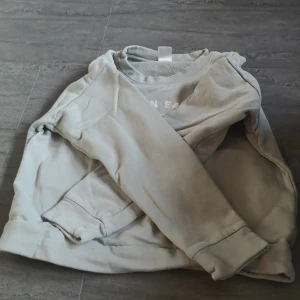 Grå sweatshirt från Kappahl - Säljer en grå sweatshirt från Kappahl med trycket 'Clean Eating Having Breakfast After You've Showered' på framsidan. Tröjan har långa ärmar och en rund halsringning. Perfekt för en avslappnad stil. Liten fläck som kan gå bort bredvid texten men priset sänks då därför också. 