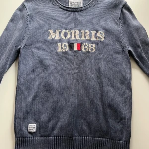 Blå tröja från Morris - Säljer en stilren blå tröja från Morris med broderad text 'Morris 1968' på framsidan. Storlek M
