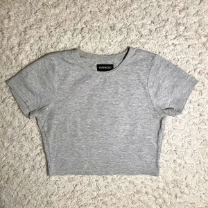 Grå ribbad croppad t-shirt från even&odd  - Säljer en stilren grå ribbad t-shirt från even&odd. Den är croppad och har korta ärmar, perfekt för en avslappnad look. Passar bra till både jeans och kjol. Skicka ett meddelande vid intresse!
