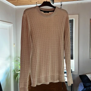 Beige stickad tröja från Jack & Jones - Säljer en stilren beige stickad tröja från Jack & Jones Premium. Tröjan har ett klassiskt kabelstickat mönster och en fräsch färg. Perfekt för en avslappnad och snygg look. Stl XL, men passar även L. Vid minsta fundering eller fråga så är det bara att höra av sig.