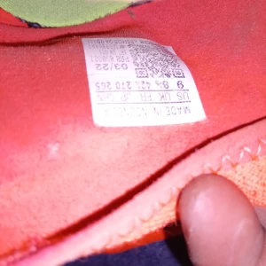 Röda fotbollsskor Adidas Predator - Snygga röda Adidas Predator fotbollsskor med grön detaljering och snörning. Skorna har en strömlinjeformad design med dobbar för optimalt grepp på planen. Perfekta för fotbollsspelare som vill ha stil och funktionalitet.