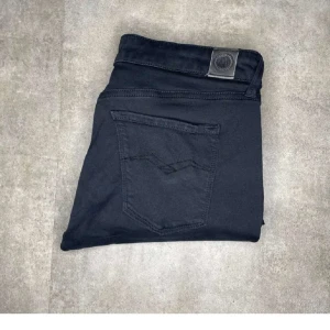 Svarta jeans från Replay - Snygga svarta dam jeans från Replay med en klassisk design. De har en knapp och dragkedja framtill samt fickor både fram och bak. Perfekta för en stilren look.