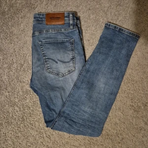 Blå jeans från Jack & Jones - Snygga blå jeans från Jack & Jones i modellen Slim/Glenn. De har en klassisk femficksdesign och en lätt slitning för en trendig look. Perfekta för en avslappnad stil. W=29, L=30. Skriv om du har några funderingar. Pris är diskuterbart!