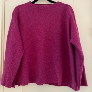 Lila stickad tröja strl M - Säljer en mysig lila stickad tröja med rund hals och långa ärmar. Perfekt för kyliga dagar och ger en härlig färgklick till garderoben. Tröjan har en enkel design som gör den lätt att matcha med olika outfits. Lila stickad tröja i strl M från Eileen Fisher.  Använd men i fint begagnat skick.  Mått Över bröstet: ca 56 cm Längd från axeln och ner: ca 56 cm  100% ull  Kommer från ett djur och rökfritt hem.   