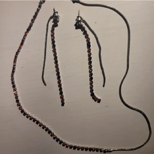 Matchande smycken - Ett par örhängen och ett matchande halsband från mexx. I silver och har diamanter i olika nyanser av röd, jättebra kvalitet.