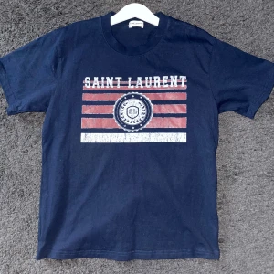 Saint Laurent Tshirt - Saint Laurent T-shirt i ett mycket bra skick. Fantastiskt kvalitet och en snygg och fräsch design. Hör av dig vid frågor, svarar gärna så tveka inte!