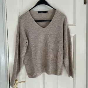 Beige stickad tröja  - Mysig beige stickad tröja från vero Moda  med v-ringning.