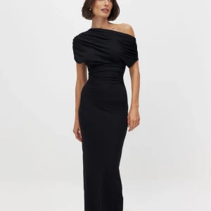 Svart långklänning - Elegant svart långklänning med offshoulder-design och draperad överdel. Klänningen har en figurnära passform som framhäver silhuetten. Perfekt för en stilfull kväll. Nypris: 599kr