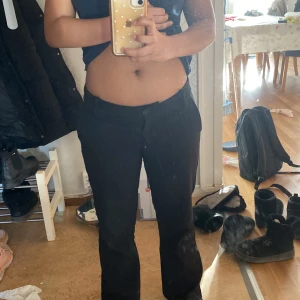 Svarta kostym byxor - Snygga svarta bootcut kostymbyxor med låg midja. Perfekta för en stilren look. Byxorna har en klassisk design med en lätt utsvängd passform som ger en modern touch.