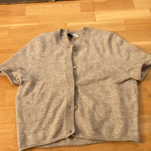 Beige kofta från h&m - Säljer en jättefin beige kortärmad kofta som använts bara ett fåtal gånger! Storlek är M men är lite mindre i storlek (men stretchig) och passar då även S. Säljer då den inte kommer till användning lika mycket! Kan även skicka bilder med tröjan på💗