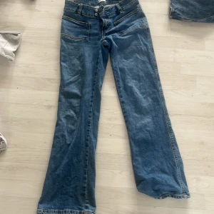 Blå jeans med vida ben - Snygga blå jeans med vida ben och låg midja. De har en klassisk femficksdesign och stängs med dragkedja och knapp. Perfekta för en avslappnad stil.