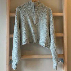 Stickad croppad tröja - Fin stickad tröja med hög krage, långa ärmar med ribbade muddar och en dragkedja framtill. Den är mysig och skön, och man kan reglera värmen mha dragkedjan. Säljer för att jag måste rensa i garderoben! Det är bara att skriva om man undrar något💞🎀