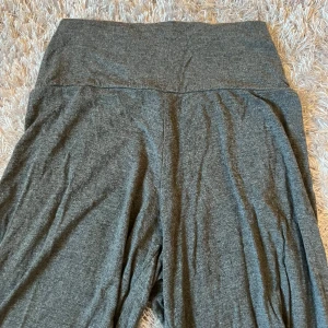 Grå mjukisbyxor - Säljer ett par bekväma grå mjukisbyxor med hög midja. Byxorna har en loose passform och är perfekta för en avslappnad stil. Tillverkade i mjukt material som ger en skön känsla hela dagen.