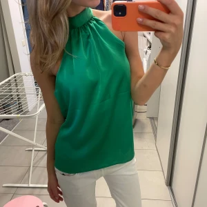 Grön halterneck topp - Snygg grön halterneck topp i satin material! Perfekt nu till våren och sommaren! Finns defekter som fläckar men syns inte så mycket + lite sliten i nacken men åter inget som syns⭐️
