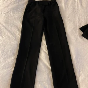 Svarta kostymbyxor - Svarta kostymbyxor från Bikbok med fin detalj fram, storlek 36. Använda 1-2ggr. Nypris 499 😇