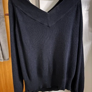 Svart stickad tröja från Vero Moda - Säljer en stilren svart stickad tröja från Vero Moda. Tröjan har en v-ringad design och långa ärmar, perfekt för kyligare dagar. Den är mjuk och bekväm, idealisk för både vardag och mer uppklädda tillfällen.