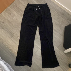 Svarta mjukisbyxor med snörning - Säljer ett par svarta mjukisbyxor med snörning i midjan. Byxorna har en loose passform och är perfekta för en avslappnad stil. De har fickor både fram och bak, vilket ger en praktisk touch.