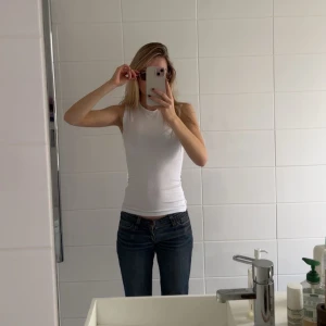 Vit ärmlös linnetopp från Weekday - Säljer en stilren vit ärmlös linnetopp från Weekday. Perfekt för varma dagar eller som lager under en jacka. Enkel men jättecool med lite accessoarer