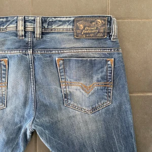 Blå jeans från Diesel - Ett par riktigt feta par jeans från Diesel. Jeansen har en jäkligt sjysst tvätt och snygga slitningar som detaljer. De är i ett mycket bra skick och säljs nu för 499 kr. Priset går att diskutera vid snabb affär! Personen på bilden är 180 cm lång o väger 75 kg. Skriv vid funderingar!