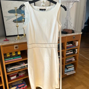 Vit klänning från Laura Clement - Elegant vit klänning från Laura Clement med en stilren design. Klänningen har en dragkedja på sidan och dekorativa sömmar i midjan. Perfekt för en chic look. Ger Parisian vibes. Har en liten fläck men kan nog gå bror i tvätten. Storlek 38 men är proffesionellt skräddarsydd för att passa 36.