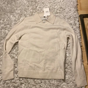 Beige Merino Volt - Säljer en stilren beige tröja från These Glory Days i mjuk merinoull. Tröjan har en klassisk krage och långa ärmar, perfekt för en elegant look. Passar bra till både jeans och chinos. Nypris 1000kr, pris är diskuterbart!