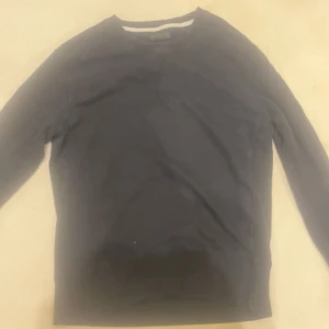 Svart långärmad tröja Tiger of Sweden - Svart långärmad tröja från Tiger of Sweden Jeans i storlek small. Enkel och stilren design med rund hals och mjukt material som känns skönt mot huden. Perfekt för dig som gillar minimalistisk stil och vill ha en tröja som funkar till allt.