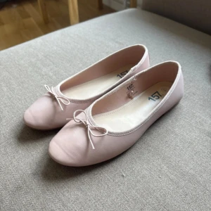 Ljusrosa ballerinaskor - Säljer ljusrosa ballerinaskor med rosett fram i storlek 39, från Lager 157. Skorna är knappt använda och i bra skick. Finns ett litet märke på den högra skon (se sista bilden). Väldigt bekväma och sitter bra. Lite bredare i storleken.