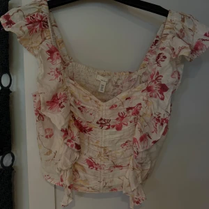 Blommig linnetopp från H&M - Supersöt linnetopp från H&M med blommigt mönster i rosa, rött och beige toner. Super bra skick.