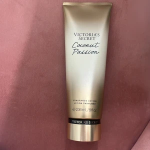 Victoria's Secret Coconut Passion lotion - Fragrance lotion Coconut Passion från Victoria's Secret med tropisk doft av kokos och vanilj. Kommer i en lyxig guldskimrande tub på 236 ml. Perfekt för dig som vill ha mjuk hud med en söt och fräsch doft. Lotionen har en krämig konsistens och är enkel att applicera.
