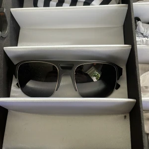 Svarta VonZipper solglasögon Ny pris 1200 - Snygga svarta solglasögon från VonZipper med klassisk pilotform och mörka linser. Ramen är i matt svart plast med detaljer i silver vid skalmarna. Perfekt för dig som vill ha en cool och stilren look i sommar.