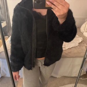 Svart pälsjacka med dragkedja - Säljer en svart pälsjacka med mjuk, fluffig känsla och hel dragkedja framtill. Jackan har hög krage perfekt för att hålla värmen. Köpt från Lindex barnavdelning men passar   S💗
