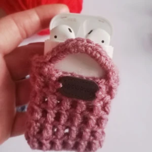 Rosa stickad mini handväska för bluetooth hörlurar - Handgjord av mig. Ny. Supersöt liten handväska i stickat rosa garn, perfekt för att bära dina AirPods eller småprylar. Väskan har ett öppet, rutigt mönster och två små handtag. Den är handgjord och har en charmig retrovibe som sticker ut i mängden.            