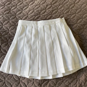 Vit plisserad kjol från STOCKH LM - Supersnygg vit kortkjol från STOCKH LM i storlek 36. Passformen är normal och materialet känns mjukt och bekvämt.