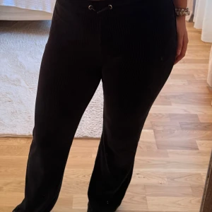 Svarta manchesterbyxor med snörning - Snygga svarta manchesterbyxor med rak passform och snörning i midjan. Byxorna har en mjuk och skön känsla, perfekta för dig som gillar en chill och stilren look. Passar till sneakers eller boots och är lätta att matcha med din favorittröja.