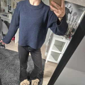 Mörkblå stickad tröja Gina Tricot - Mysig mörkblå stickad tröja från Gina Tricot med rund hals och ribbade detaljer vid ärmslut och nederkant. Modellen är loose fit och har långa ärmar, perfekt för att chilla eller hänga med kompisar. Enkel och stilren design som funkar till jeans eller mjukis.