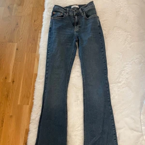 Blå bootcut jeans från Gina Tricot - Säljer ett par blå bootcut jeans från Gina Tricot, modell Perfect Jeans. De har klassisk femficksdesign, dragkedja och knapp framtill samt snygga kontrastsömmar. Jeansen är i ett mjukt denimtyg och har en högre midja💙💙