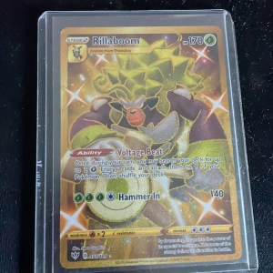 Rillaboom - Cool och glittrande Pokémon-kort med Rillaboom! Perfekt för samlare och fans av Pokémon. Kortet har specialförmågan Voltage Beat och en kraftfull attack. Ett måste för dig som vill ha något unikt i din samling!