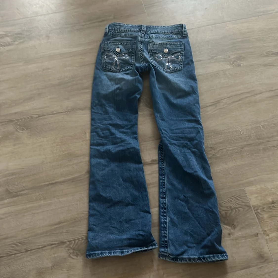 Blå bootcut jeans med fickor där bak. - 1