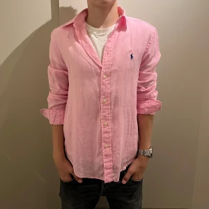 Rosa linneskjorta från Polo Ralph Lauren - ✨Snygg och stilren helt oanvänd skjorta från Ralph Lauren i ljusrosa. Perfekt både till vardag och. fest ✨ passformen är normal som passar folk runt 170-180 med ett skönt och lätt material med en klassisk Polo loga på bröstet 😁