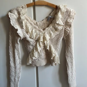 Beige stickad tröja med spetsvolang - Supersötoxh trendig beige stickad tröja från Zara. Tyvärr aldrig kommit till användning och är därmed i väldigt bra skick. Passar så bra nu inför skolstarten och hösten om man vill ha en mer unik och snygg stickad tröja💗