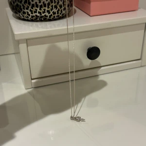 Sött silverhalsband med hjärta L8H - Ett tunt och stilrent halsband i silver med ett litet hjärthänge och en pil. Perfekt för dig som gillar enkla smycken med en romantisk touch. Passar till alla outfits och är lätt att matcha med andra smycken