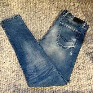 Replay Anbass jeans  - Säljer ett par Replay Anbass jeans i snyggt tvättad blå färg med  riktigt feta slitningar jeansen har inga tecken på användning och är i ett 8/10 skick skriv vid fler funderingar !! Juste längd på jeansen är 30 