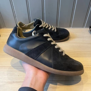 Maison margiela skor  - Säljer dessa sjukt feta och efterfrågade Maison margiela Gat skorna i storlek 43. Skorna är i perfekt skick, däremot finns en defekt som syns på bild 4 och 5, in och utsida av skon där de spruckit lite. Däremot varken något som syns eller känns av vid användning. Dustbags samt tags ingår. Hör av er vid eventuella frågor! 