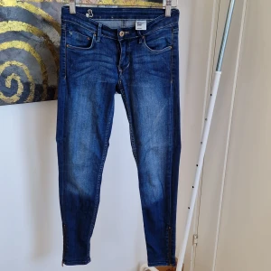 Blå jeans med dragkedja - Snygga blå jeans med dragkedja vid bensluten. Klassisk femficksdesign och knappgylf. Perfekta för en avslappnad stil.