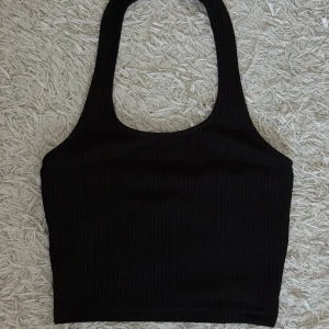Svart ribbad topp från H&M - Svart topp från H&M med halterneck