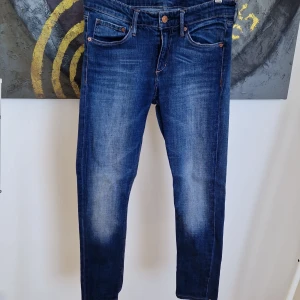Blå jeansbyxor - Snygga blå jeansbyxor med en klassisk femficksdesign och knappgylf. De har en lätt tvättad look och är perfekta för en avslappnad stil. Passar bra till både sneakers och kängor.