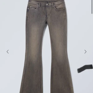 Grå bootcut jeans från weekday - Snygga grå bootcut jeans med en klassisk femficksdesign och en lätt tvättad look som ger en vintage känsla. Perfekta för en avslappnad stil. Midjemåttet är 33, innerbenslängden 76💗
