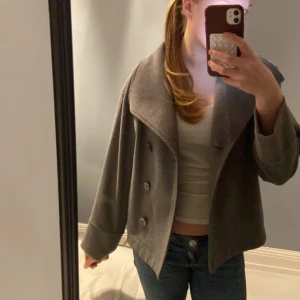Gina grå kappa - Säljer en snygg grå jacka från gina efter som den tyvärr blivit för kort i armarna för mig, den ör i storlek 146/152 men passar storleken över och xs❤️ inga defekter 