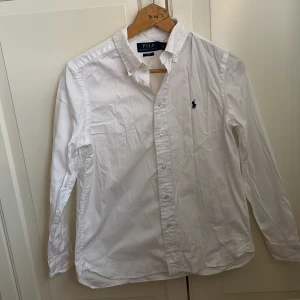 Vit skjorta från Ralph Lauren - Säljer en en fräsch raulph lauren skjorta endast användit den några gånger så den är så gott som nytt. Den är äkta fråga om om du är intresserad eller har några mer frågor.